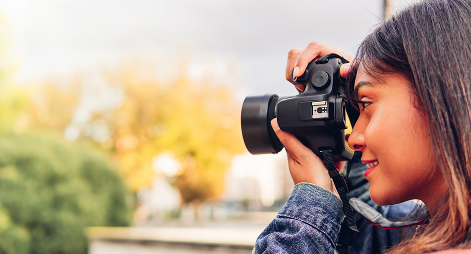 Photographer woman taking a picture with her camera on a trip.